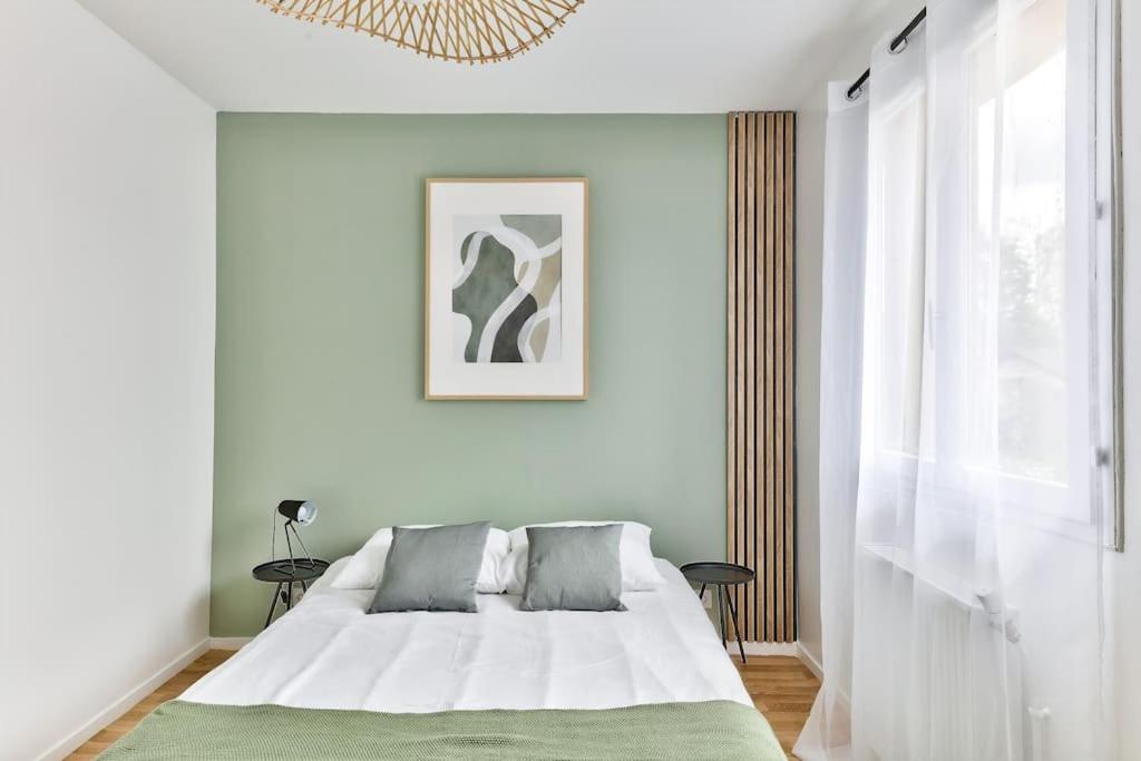 Chambres — Lit blanc, mur vert sage, lumière naturelle douce